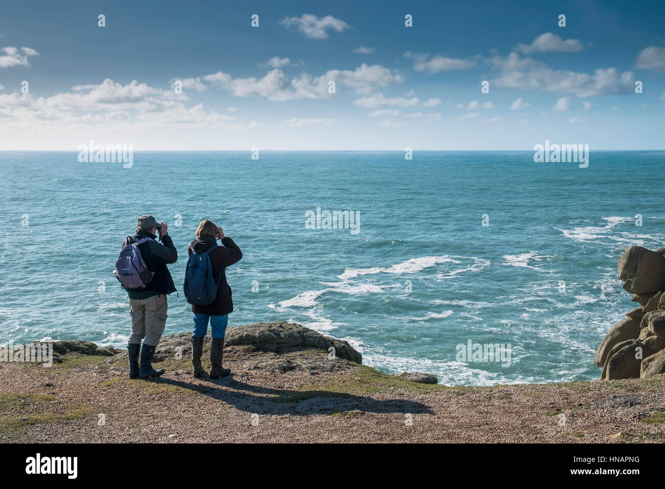 Two walkers stand on Gwennap Head in Cornwall, England. Stock Photo