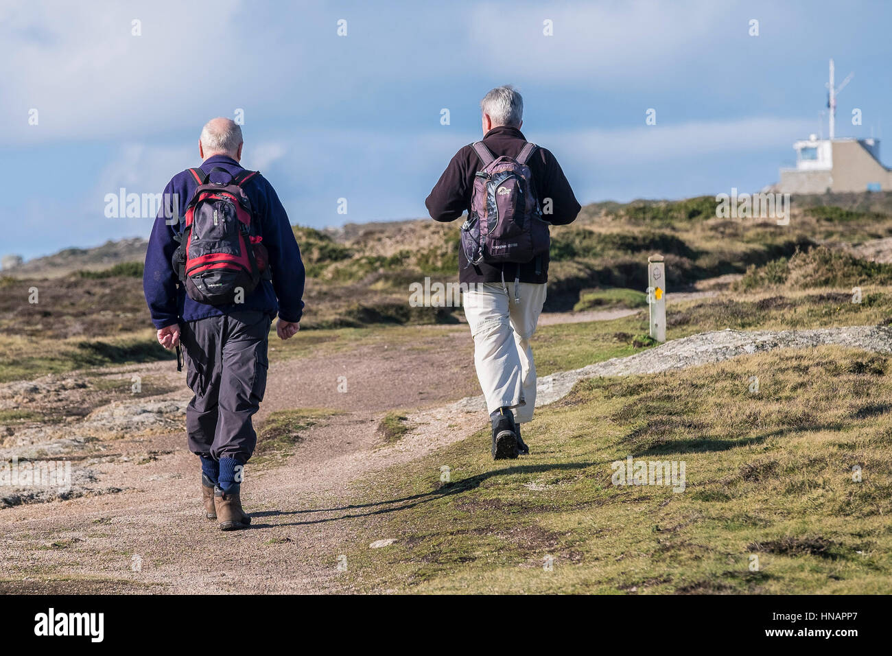 Two walkers on the South West Coastal Path on Gwennap Head in Cornwall, England. Stock Photo