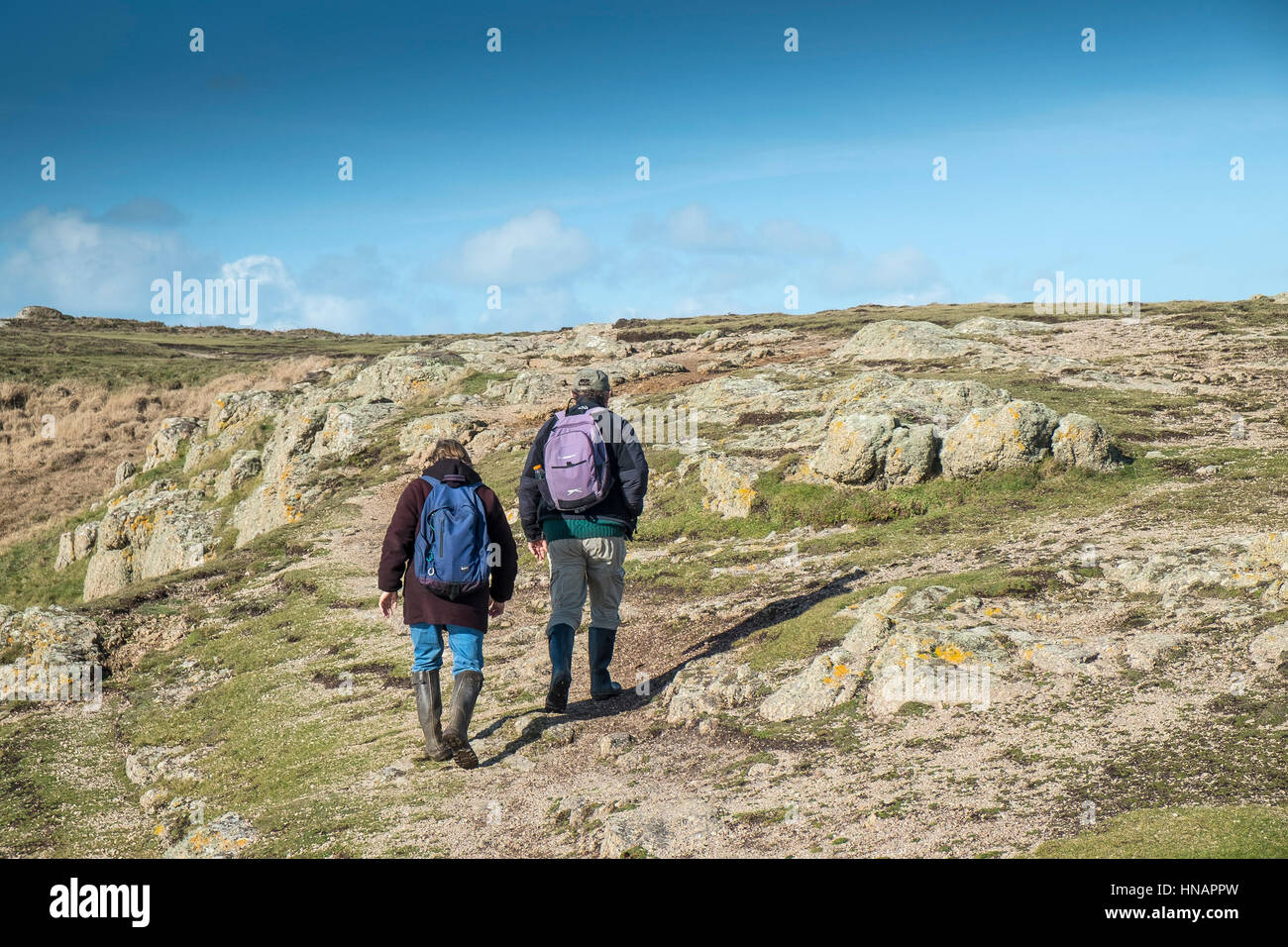 Two walkers on the South West Coastal Path on Gwennap Head in Cornwall, England, UK. Stock Photo