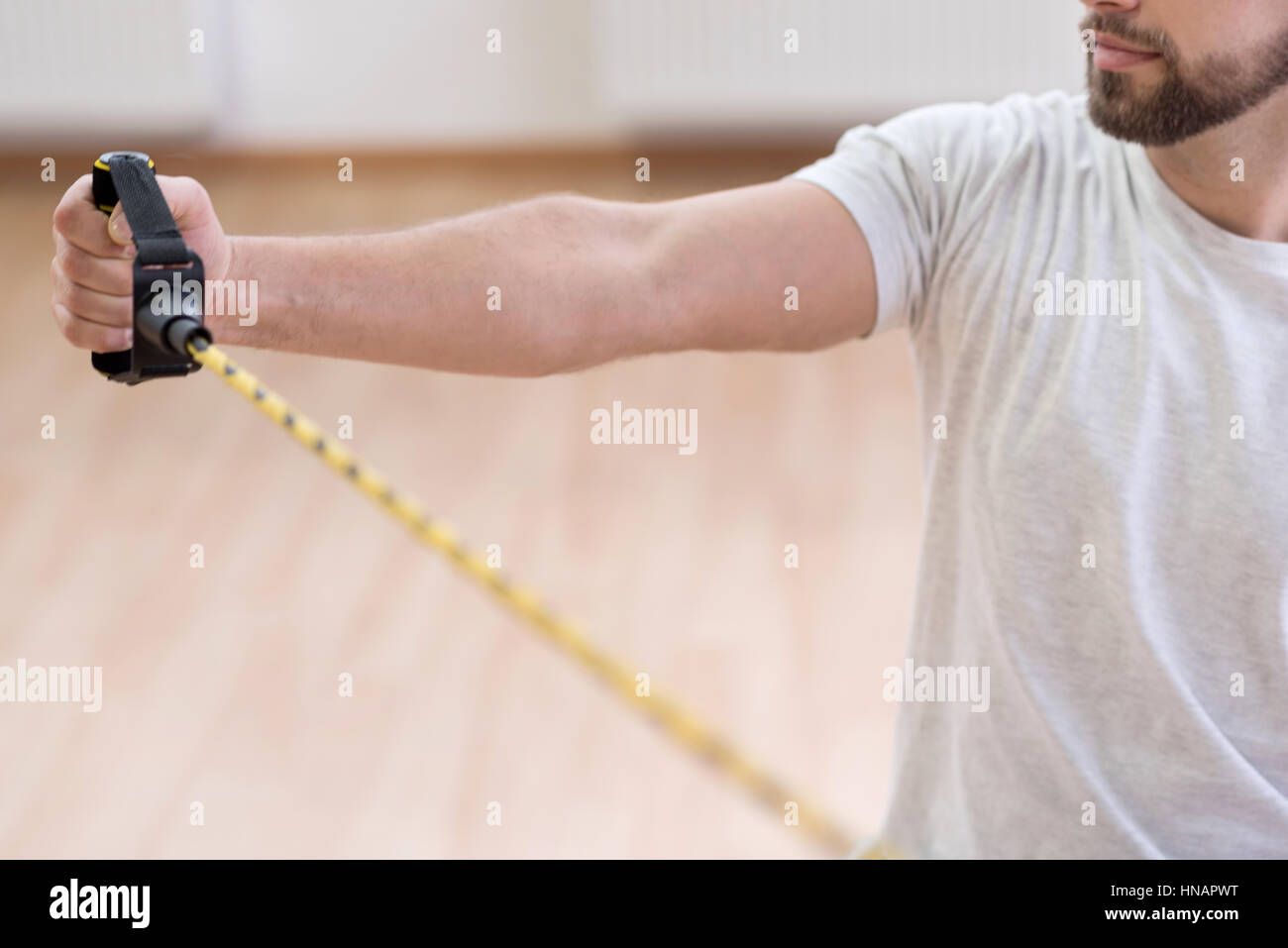 Concentrated young disabled stretching the rubber cable in the gym Stock Photo