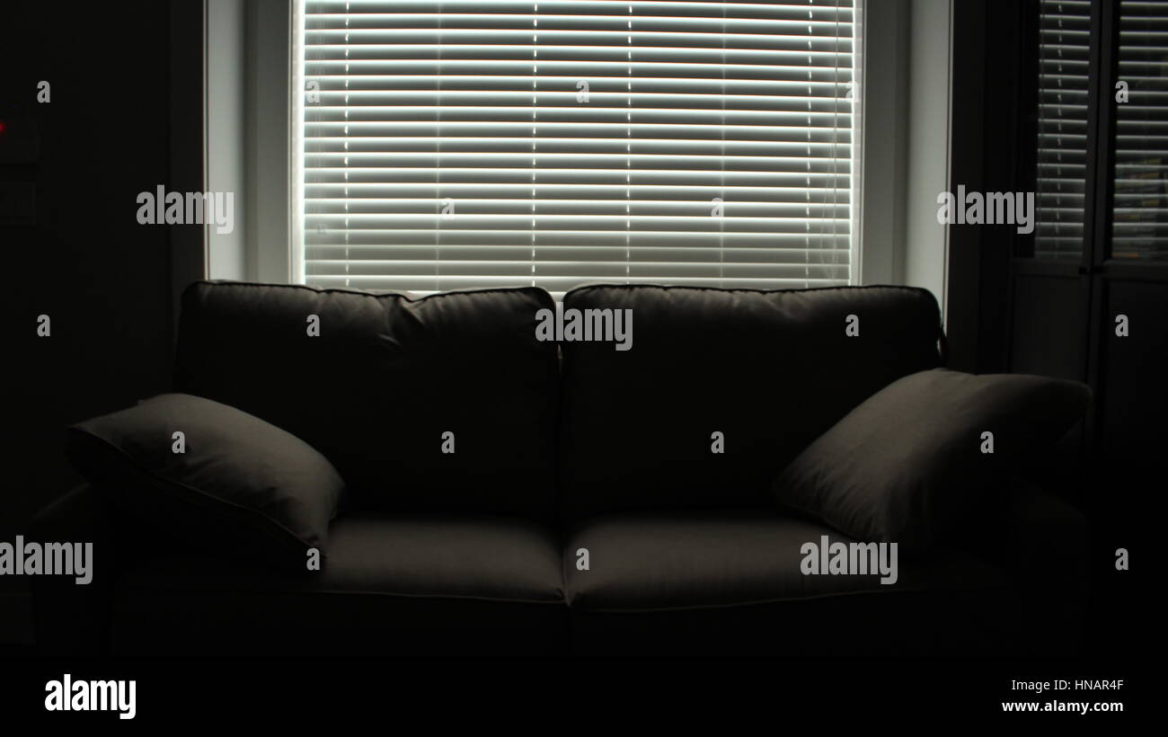 A couch in the dark Stock Photo