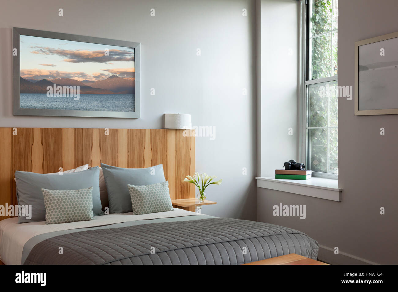 Modern style bedroom with custom wood headboard. Stock Photo