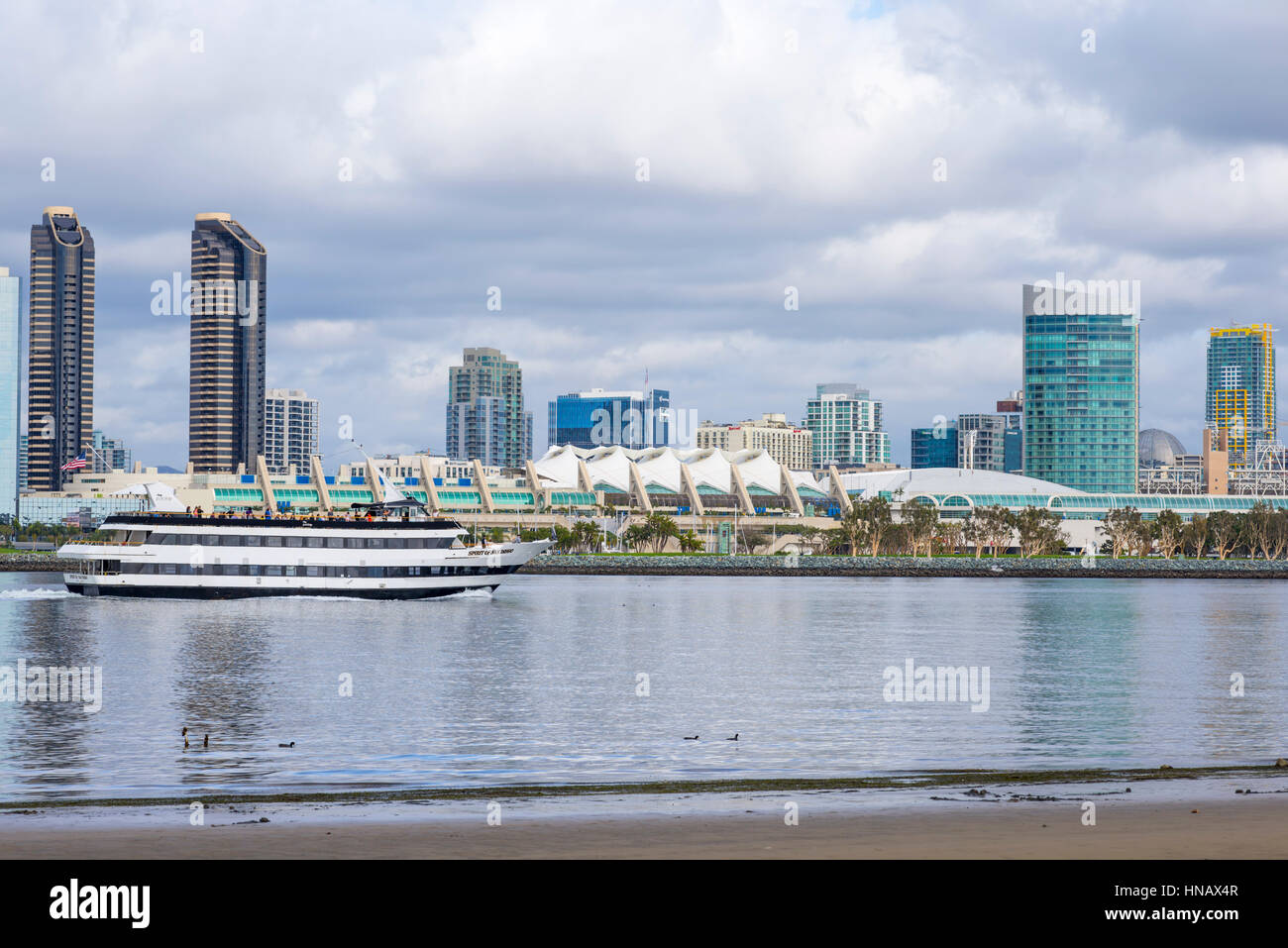 A harbor excursion boat on San Diego Harbor with the San Diego Skyline. View is from Coronado