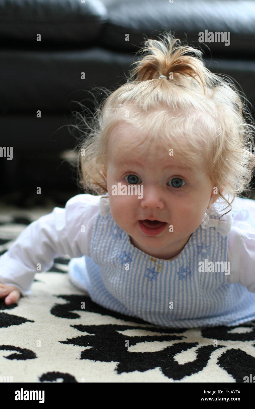 baby girl learning to crawl, lying on her tummy, tummy time Stock Photo