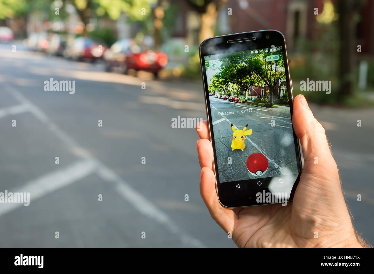 Royalty-Free photo: Person holds smartphone with Pokemon Go application  running