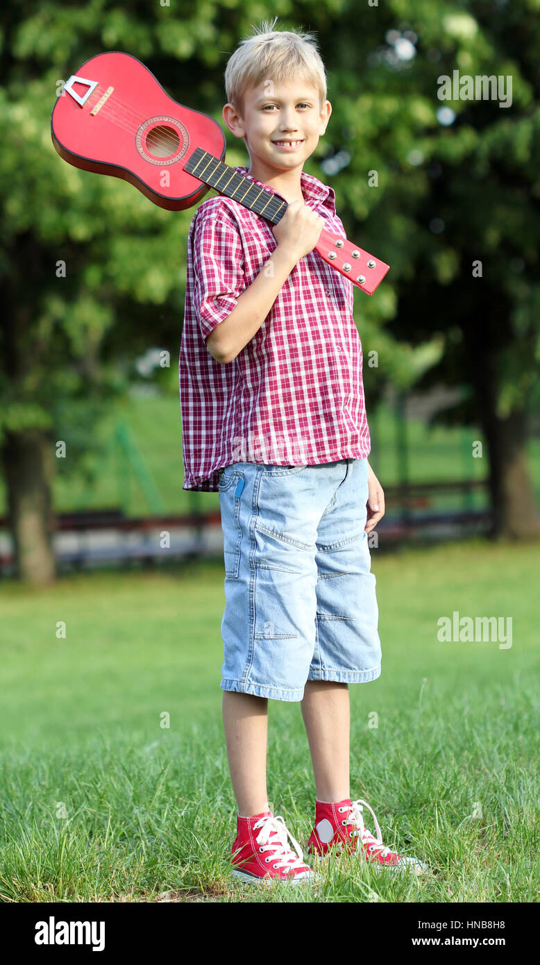 happy boy with guitar in park Stock Photo