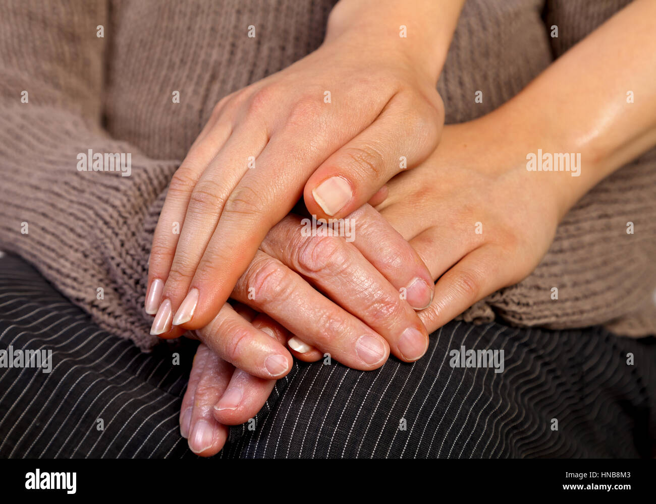 Nurse holding elderly wrinkled hand Stock Photo