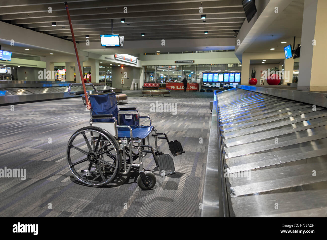 Empty Wheelchair in Airport Baggage Area Stock Photo