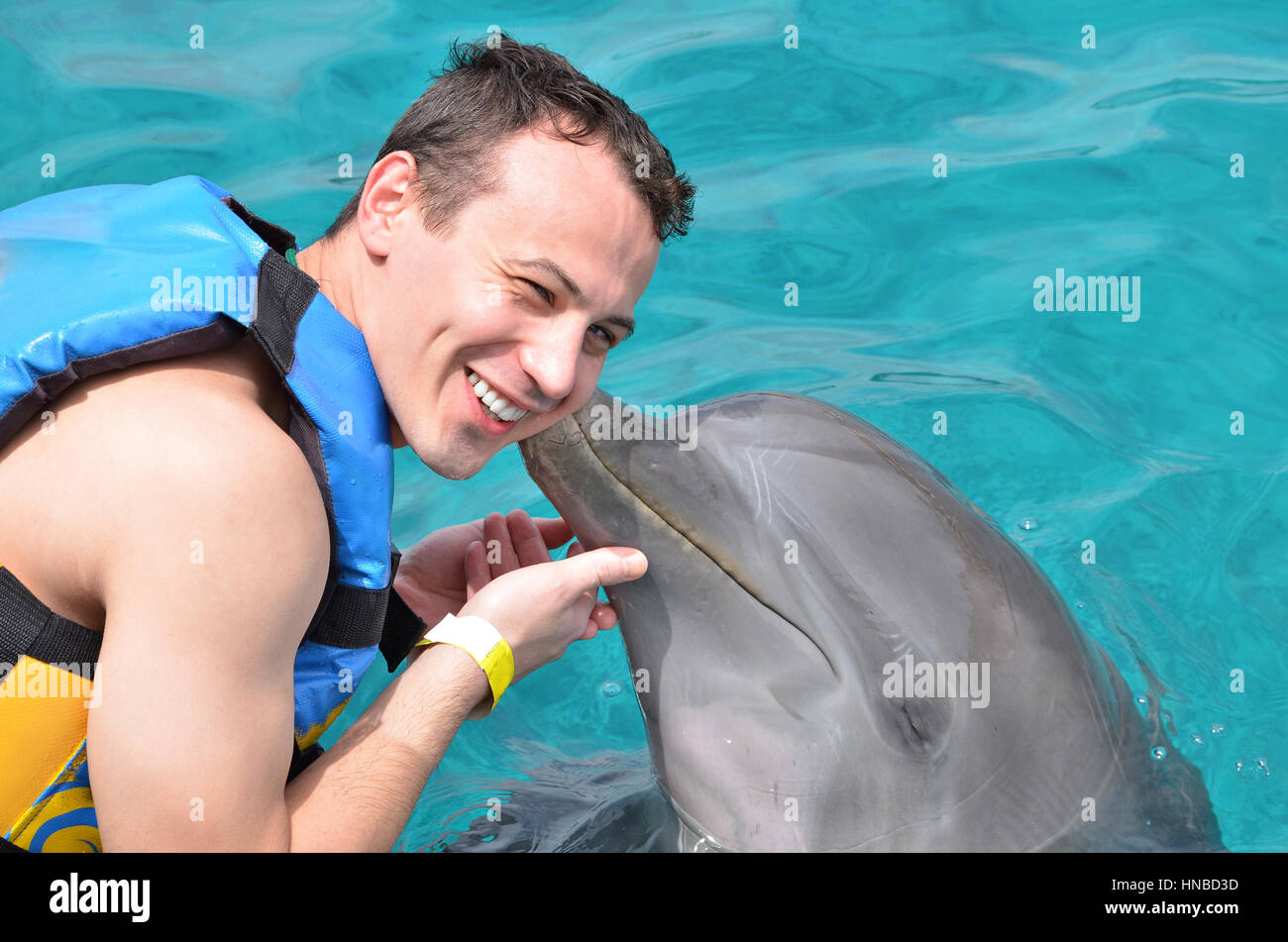 dolphin kiss man in blue clean caribbean water Stock Photo