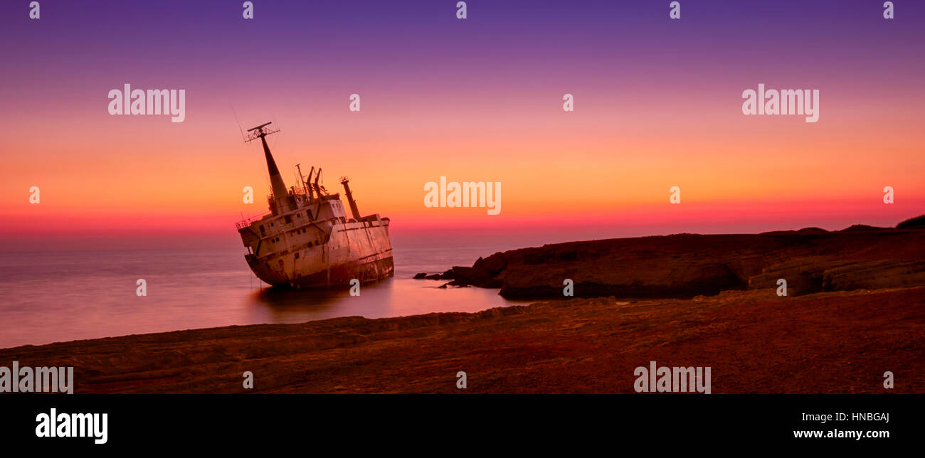 Seascape: famouse boat, shipwrecked near the rocky shore at the sunset. Mediterranean, near Paphos. Cyprus. Stock Photo