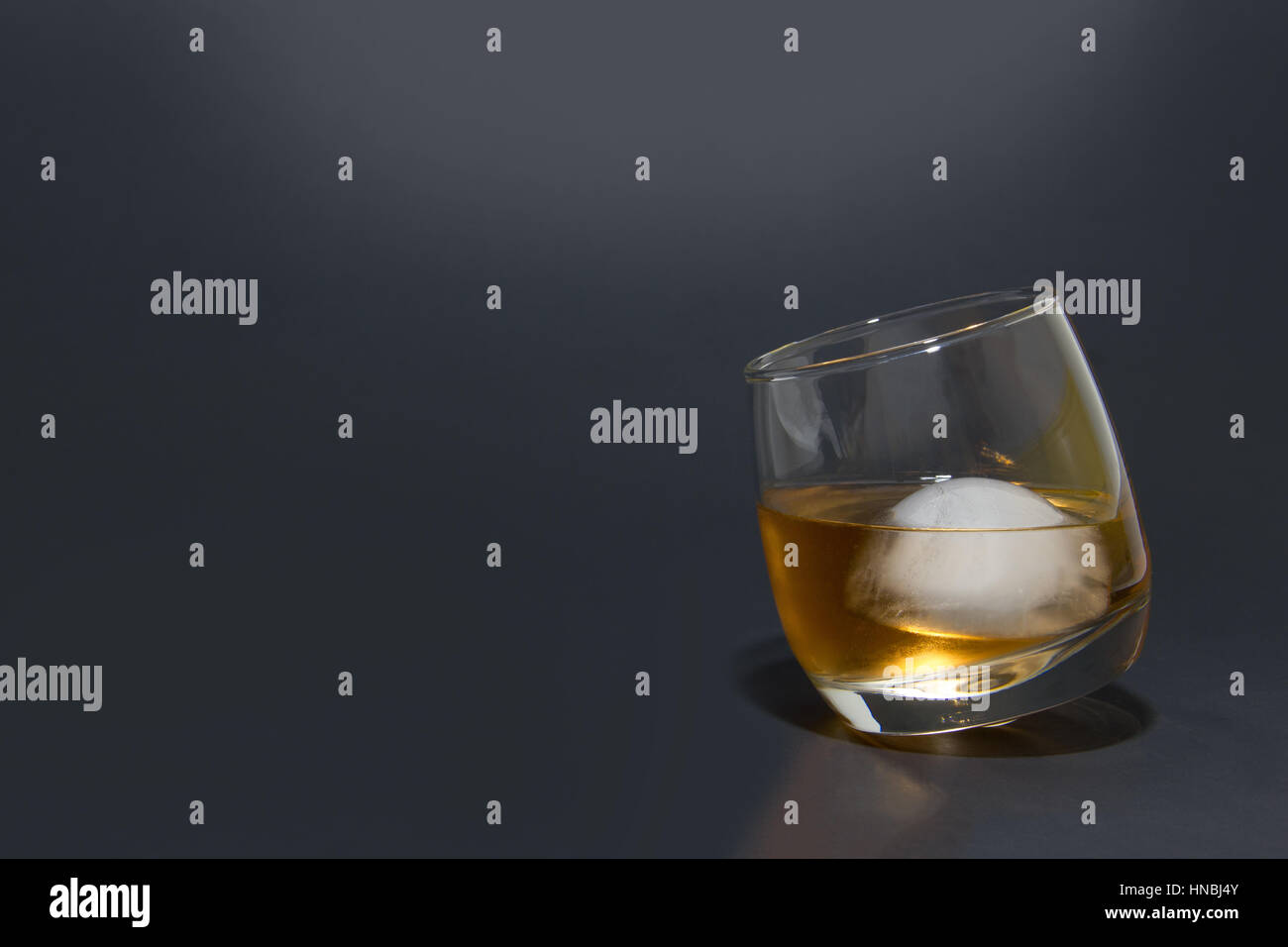 Whiskey on ice in a glass, copy space, black background Stock Photo