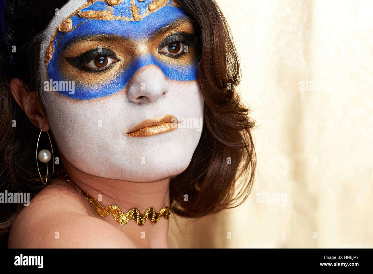 woman face with painted blue and golden mask Stock Photo