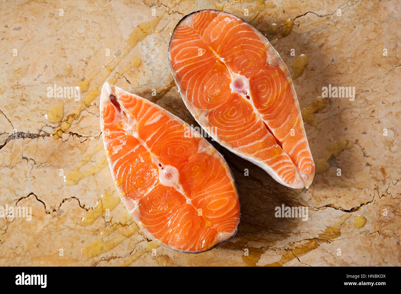 Two fresh raw salmon steaks with olive oil on marble top Stock Photo ...