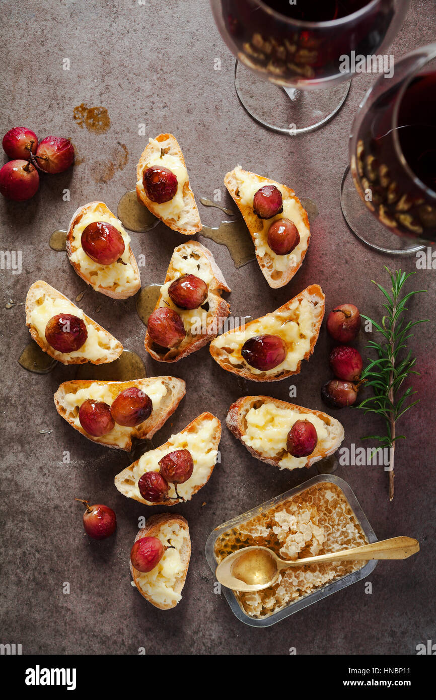 red wine and appetizer with Canapes with cheese, grapes, wine, honey