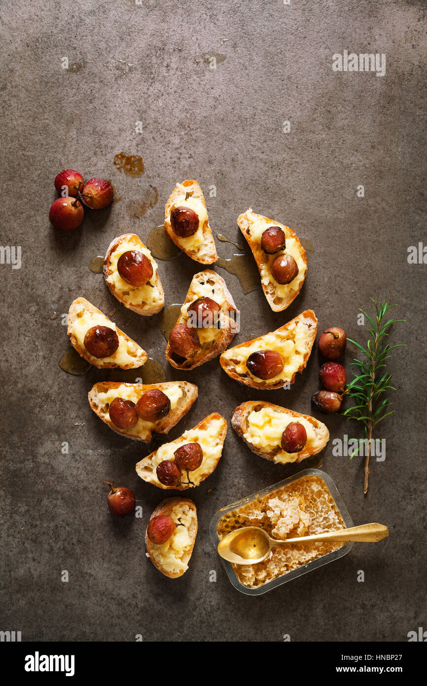 Canapes with baked Camembert cheese, grapes and honey bruschette on a