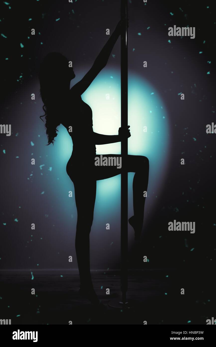 Silhouette of young slim fit woman pole dancer with very long hair  against pole with spotlight in the background creating a dramatic pose and shape Stock Photo