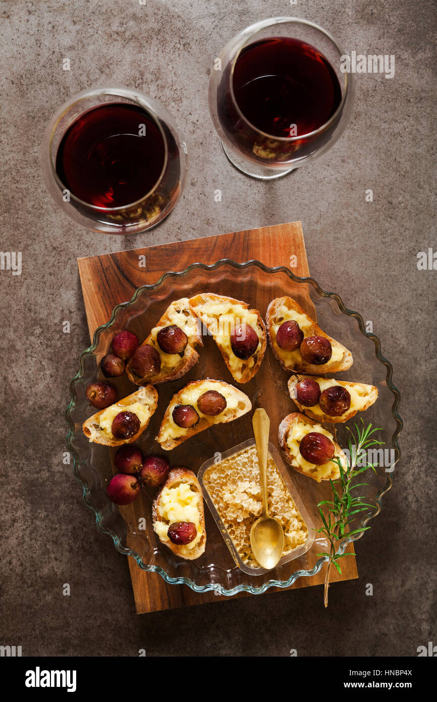 red wine and appetizer with Canapes with cheese, grapes, wine, honey