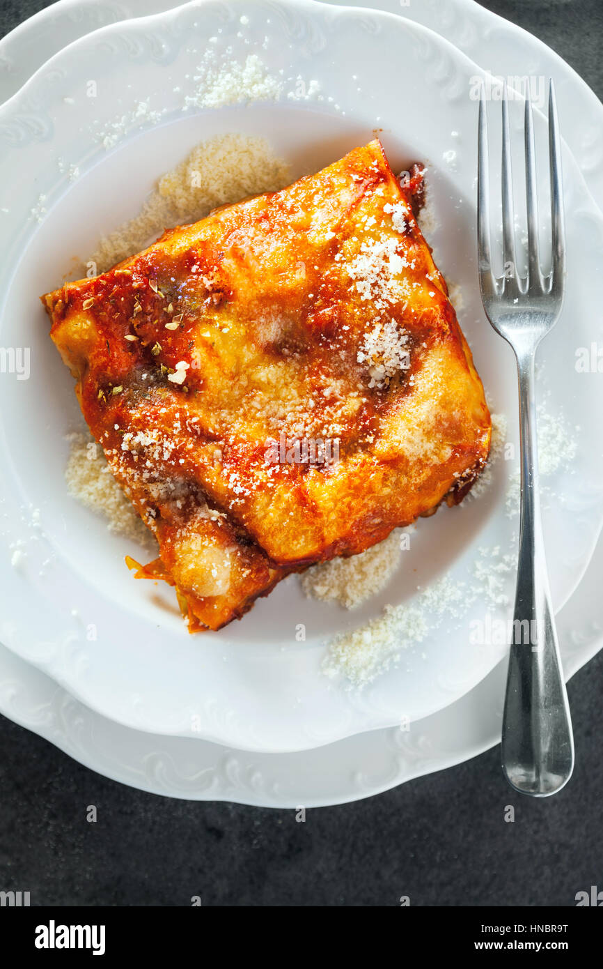 Lasagne with cheese layered between sheets of traditional Italian pasta served on a white plate
