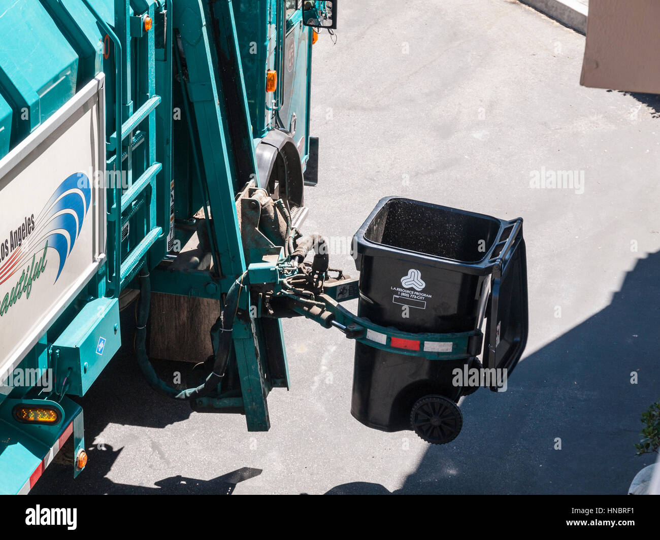 Los Angeles, California, USA - July 13, 2010:  City of Los Angeles Department of Sanitation automated trash truck arm at work. Stock Photo