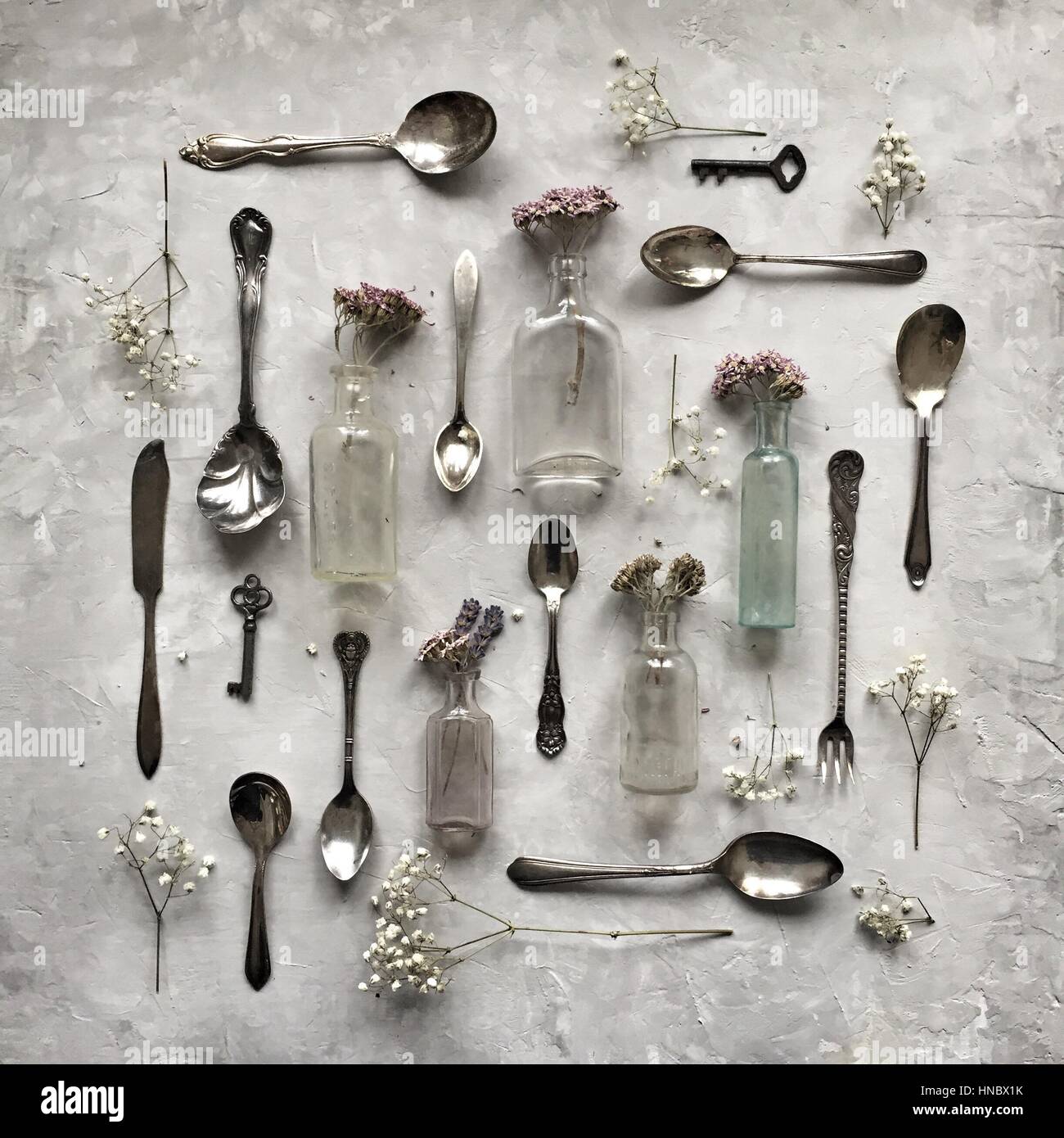 Silver spoons, vintage bottles and dried flowers Stock Photo