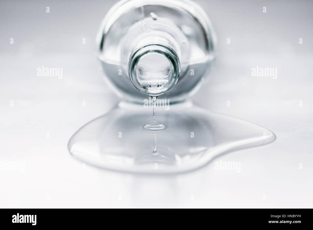 Bottle lying on table with water coming out Stock Photo
