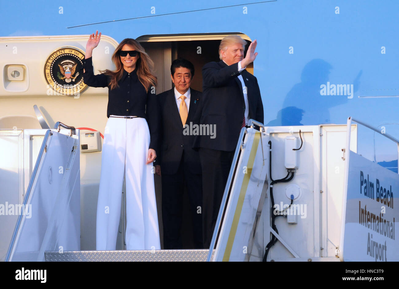 West Palm Beach, Florida, USA. 10th Feb, 2017. U.S. President Donald Trump (R) and First Lady Melania Trump (L) wave after arriving on Air Force One at Palm Beach International Airport in Florida on February 10, 2017. Trump was also accompanied by Japanese Prime Minister Shinzo Abe (center) and his wife, Akie Abe. President Trump invited the Japanese leader to spend the weekend at Trump's Mar-A-Lago estate in Palm Beach, Florida, dubbed the 'Winter White House', where they will hold meetings and play golf. Credit: Paul Hennessy/Alamy Live News Stock Photo