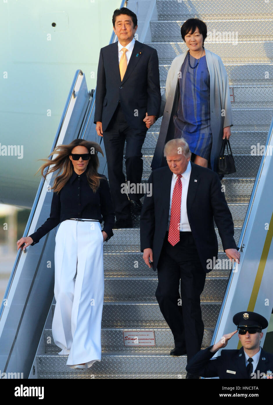 West Palm Beach, Florida, USA. 10th Feb, 2017. U.S. President Donald Trump (bottom R) walks down the stairway from Air Force One after arriving at Palm Beach International Airport in Florida on February 10, 2017. Trump was accompanied by First Lady Melania Trump (bottom L), and by Japanese Prime Minister Shinzo Abe (top L) and his wife, Akie Abe (top R). President Trump invited the Japanese leader to spend the weekend at Trump's Mar-A-Lago estate in Palm Beach, Florida, dubbed the 'Winter White House', where they will hold meetings and play golf. Credit: Paul Hennessy/Alamy Live News Stock Photo