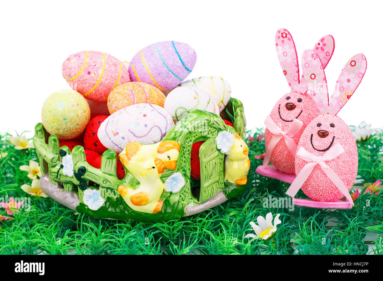 Easter decoration with colorful eggs in basket and bunnies on ...