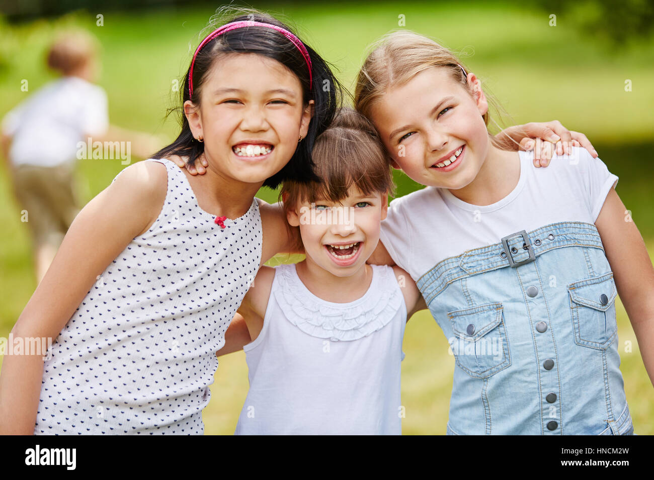 Three laughing girls as friends in intercultural happy team portrait Stock Photo