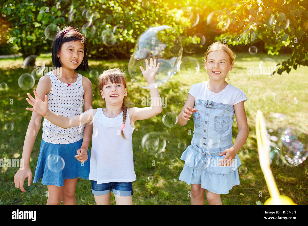 Children playing with soap bubbles in summer at the park Stock Photo ...