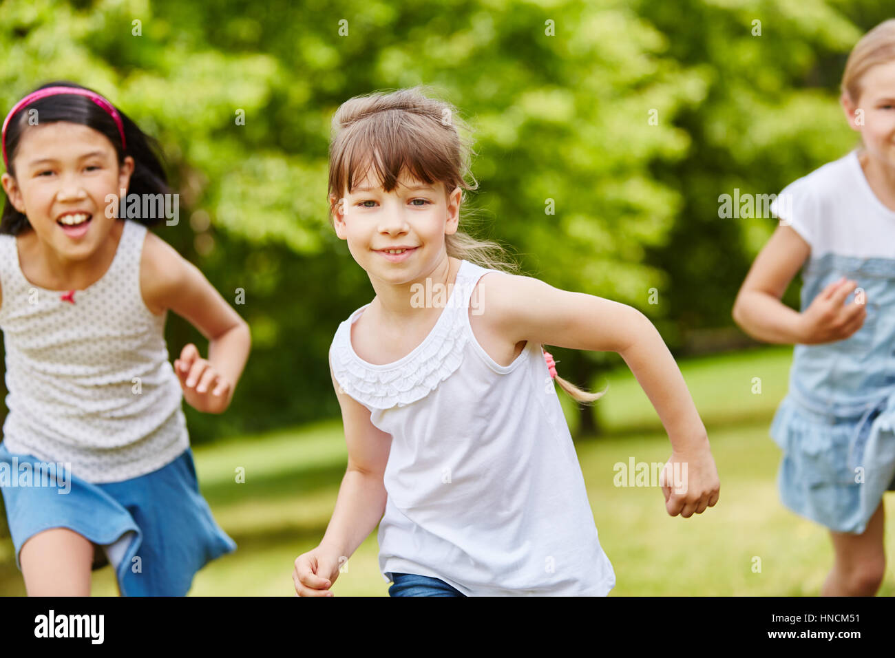 Group of kids running in the park during kindergarden race Stock Photo ...