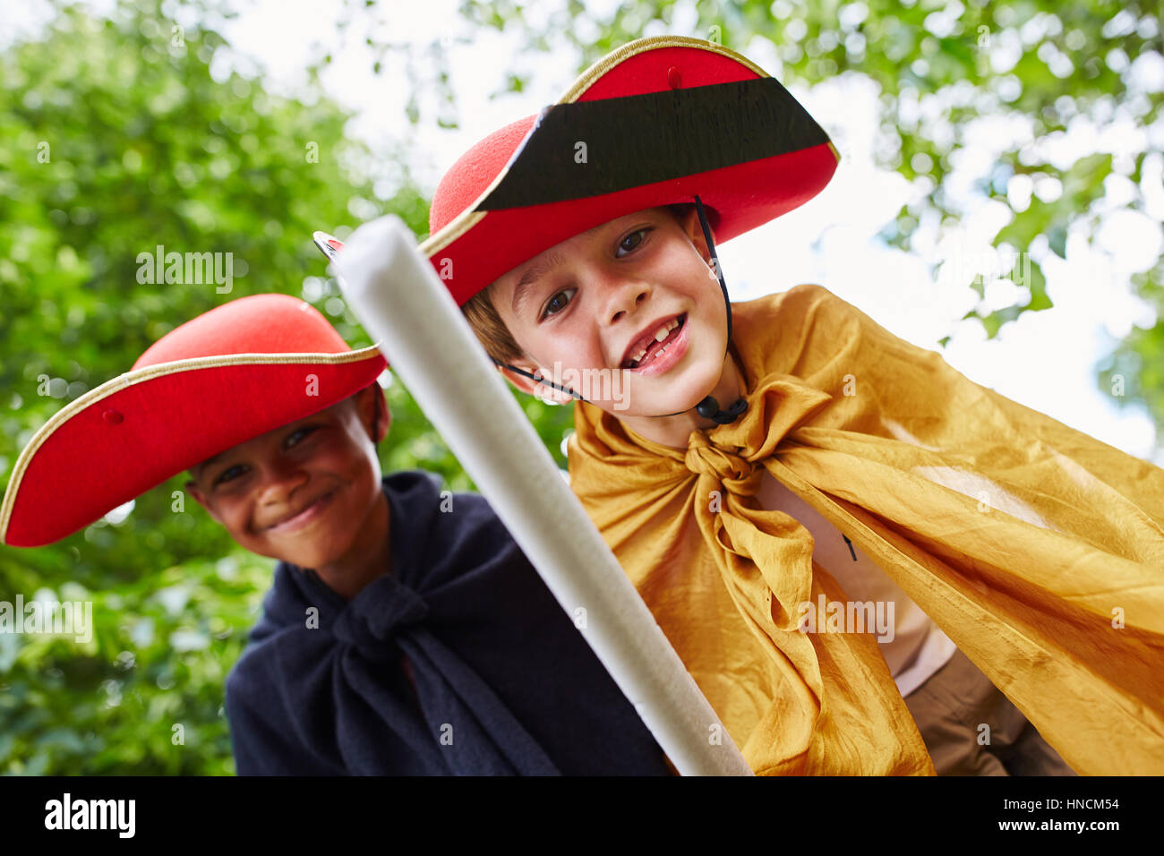 Two boys dressed up like knights playing in the park Stock Photo