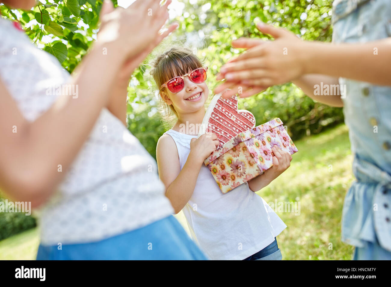 Girls celebrate friend's birthday and clap their hands Stock Photo