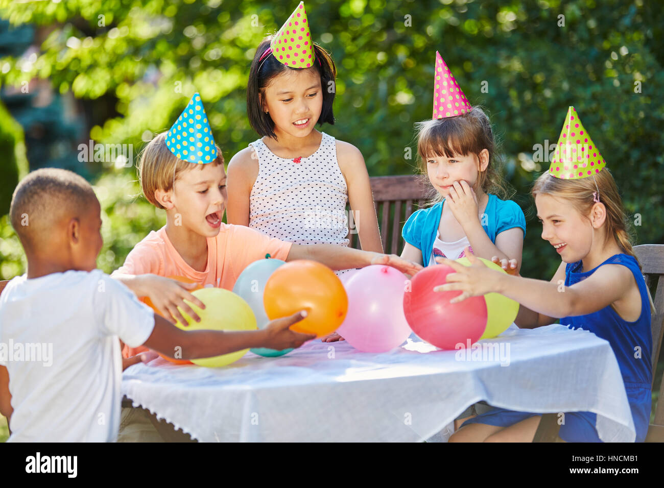 Children having fun at interracial childrens party in summer in garden Stock Photo