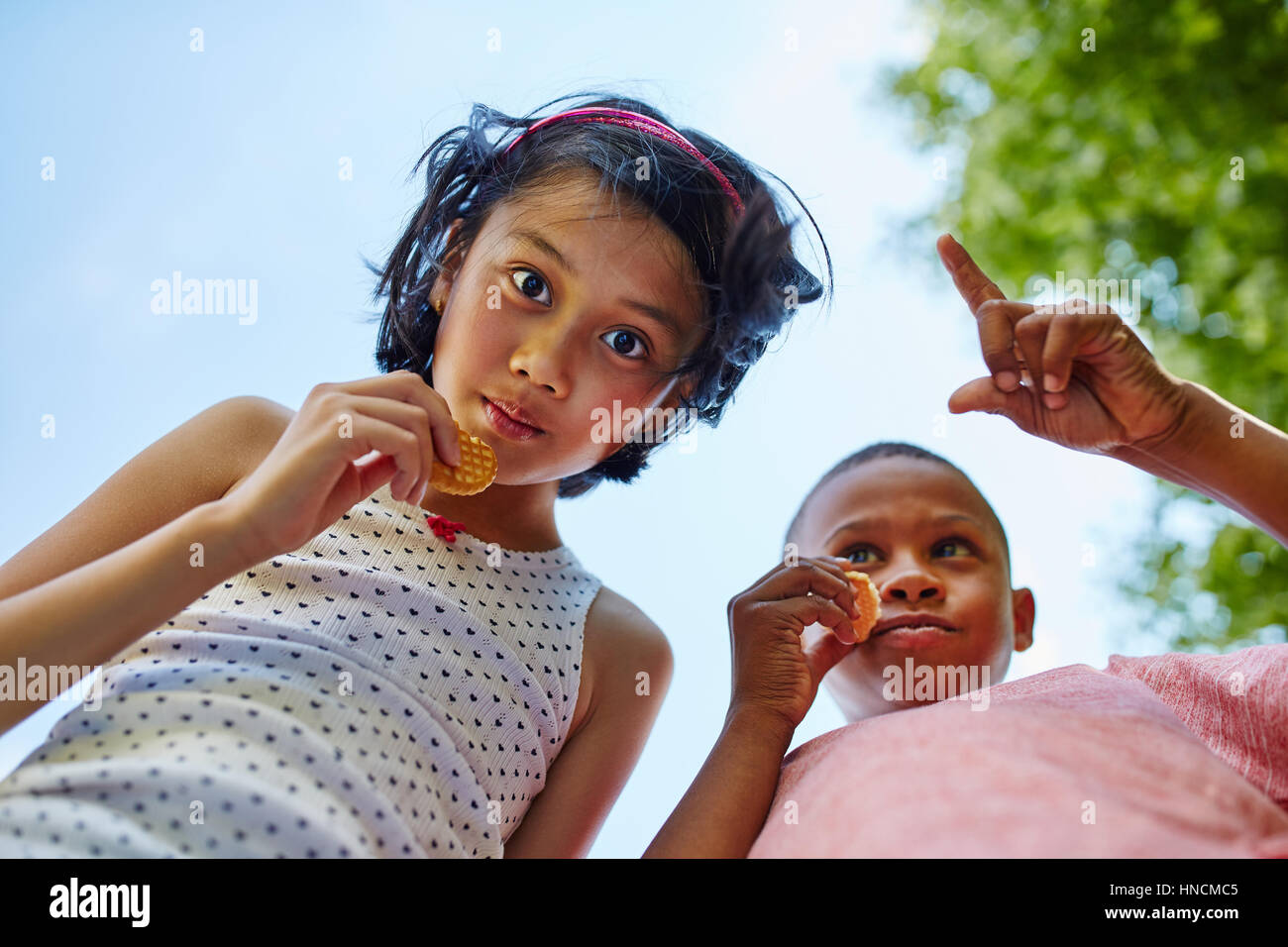 Boy and girl eat cookies together in the summer during vacation Stock Photo