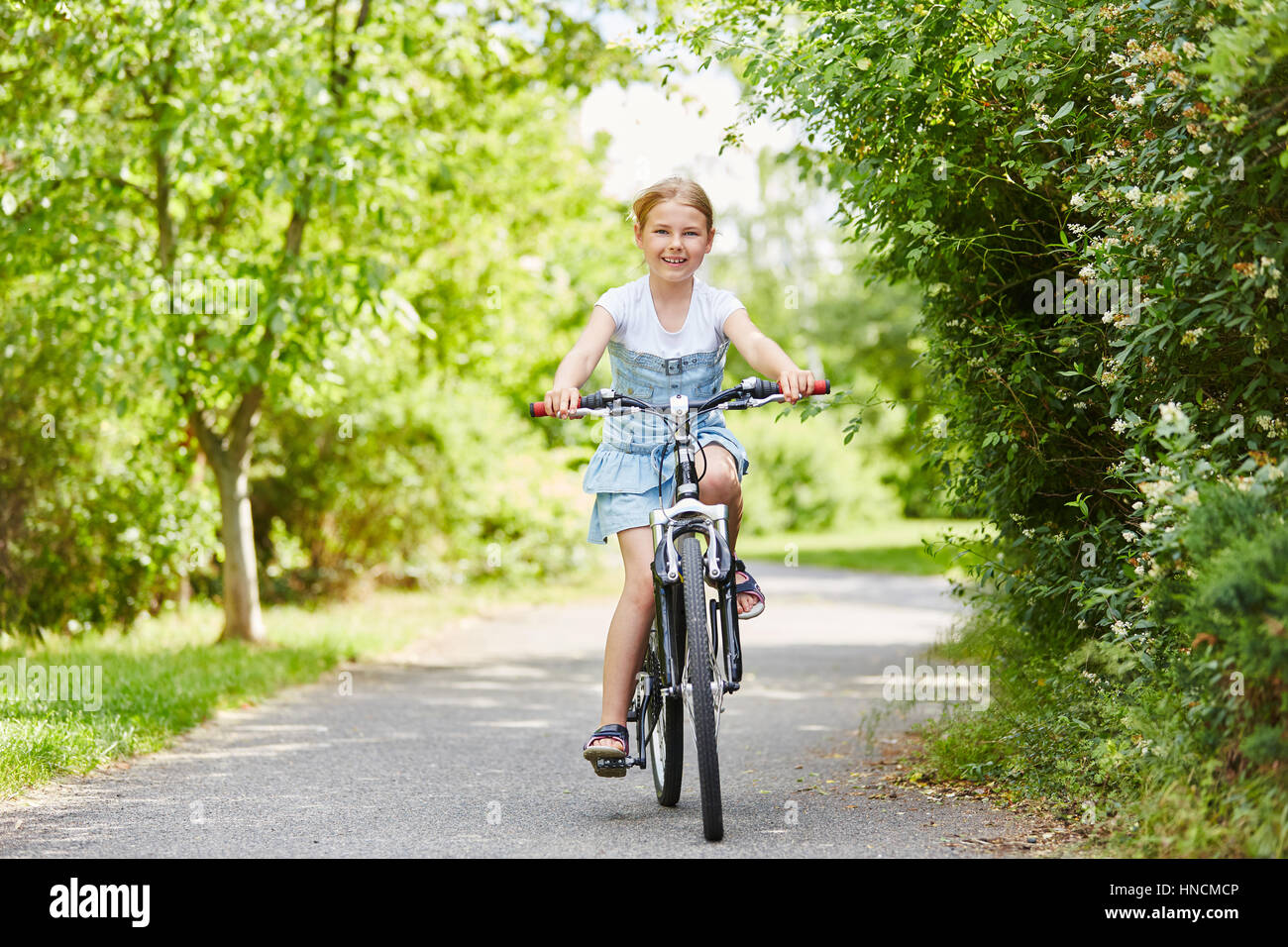 Girl making cycling tour with bicycle for fun in summer Stock Photo