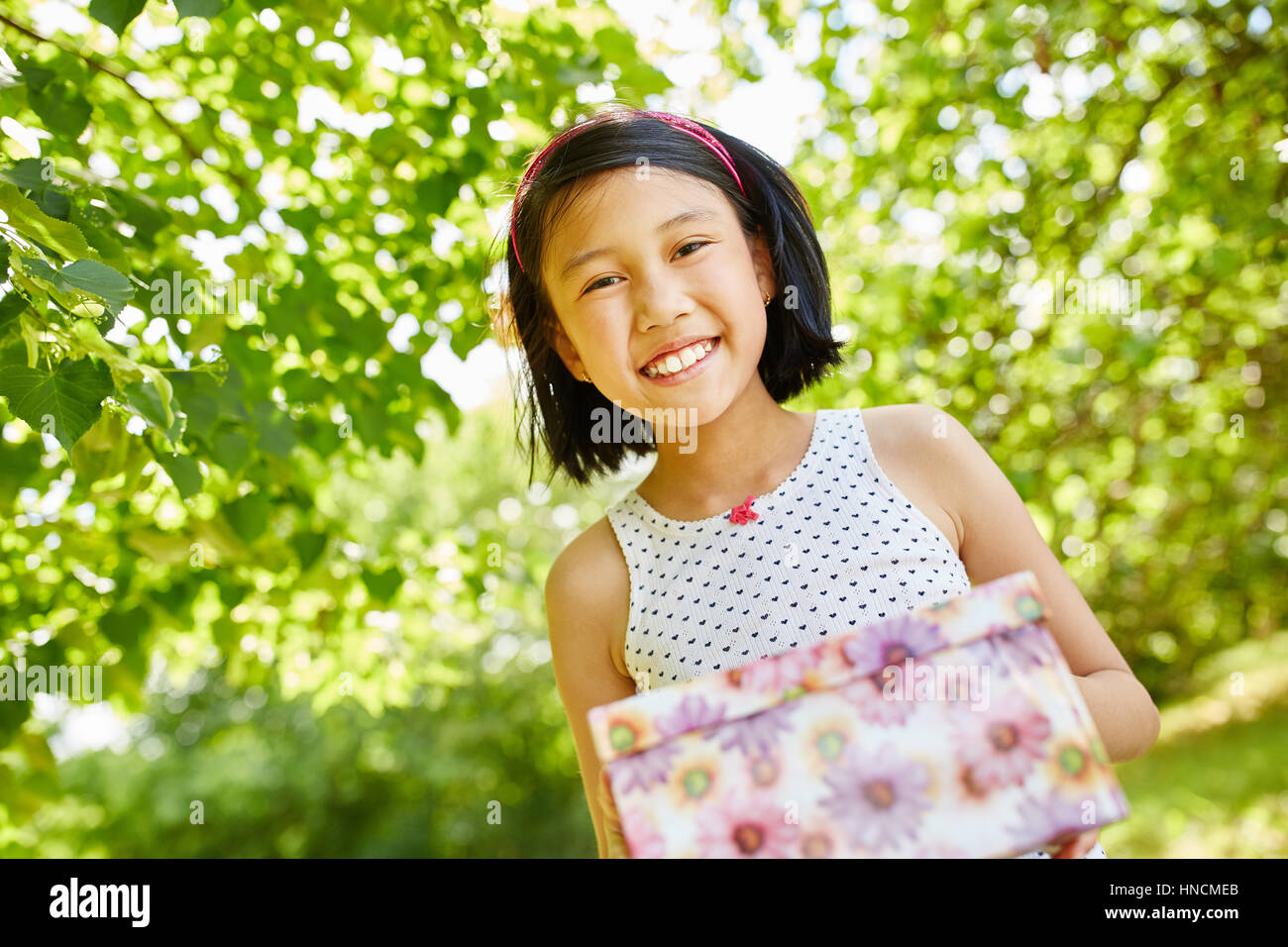 Asian girl as birthday child content with birthday gift Stock Photo