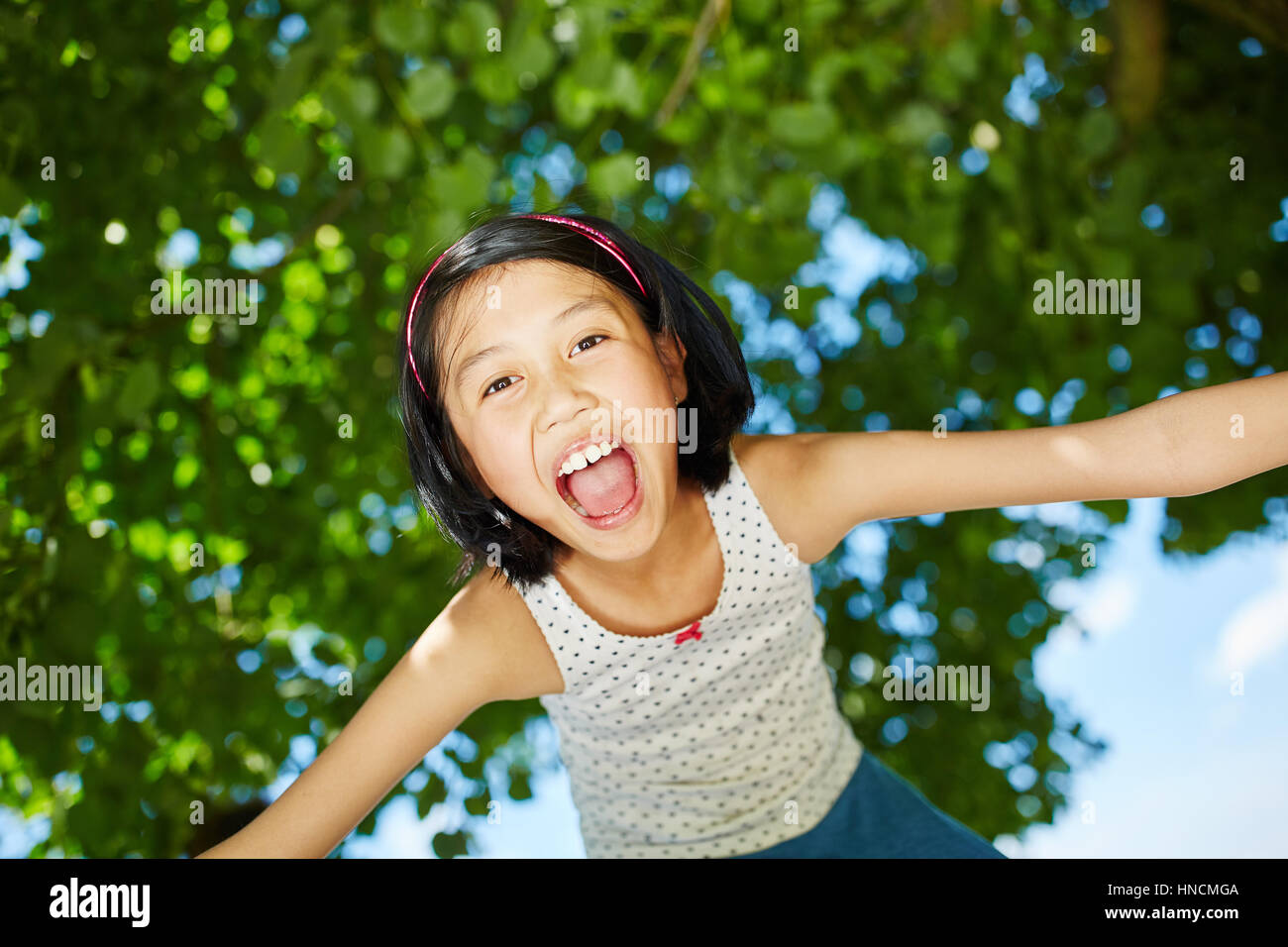 Happy asian girl opens mouth with enthusiasm laughing and has fun Stock Photo