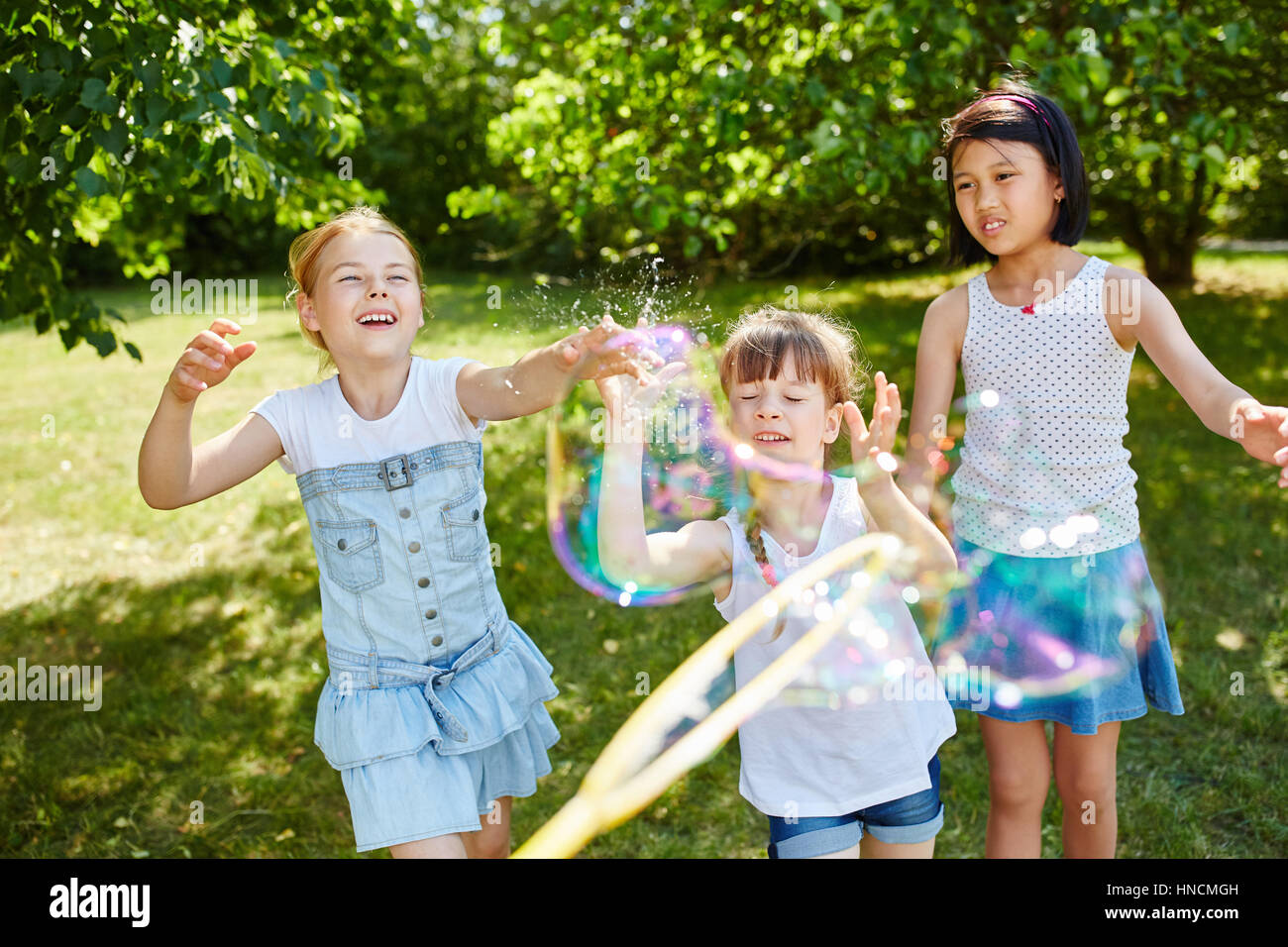 Children play with fragile soap bubbles and have fun in the park Stock ...