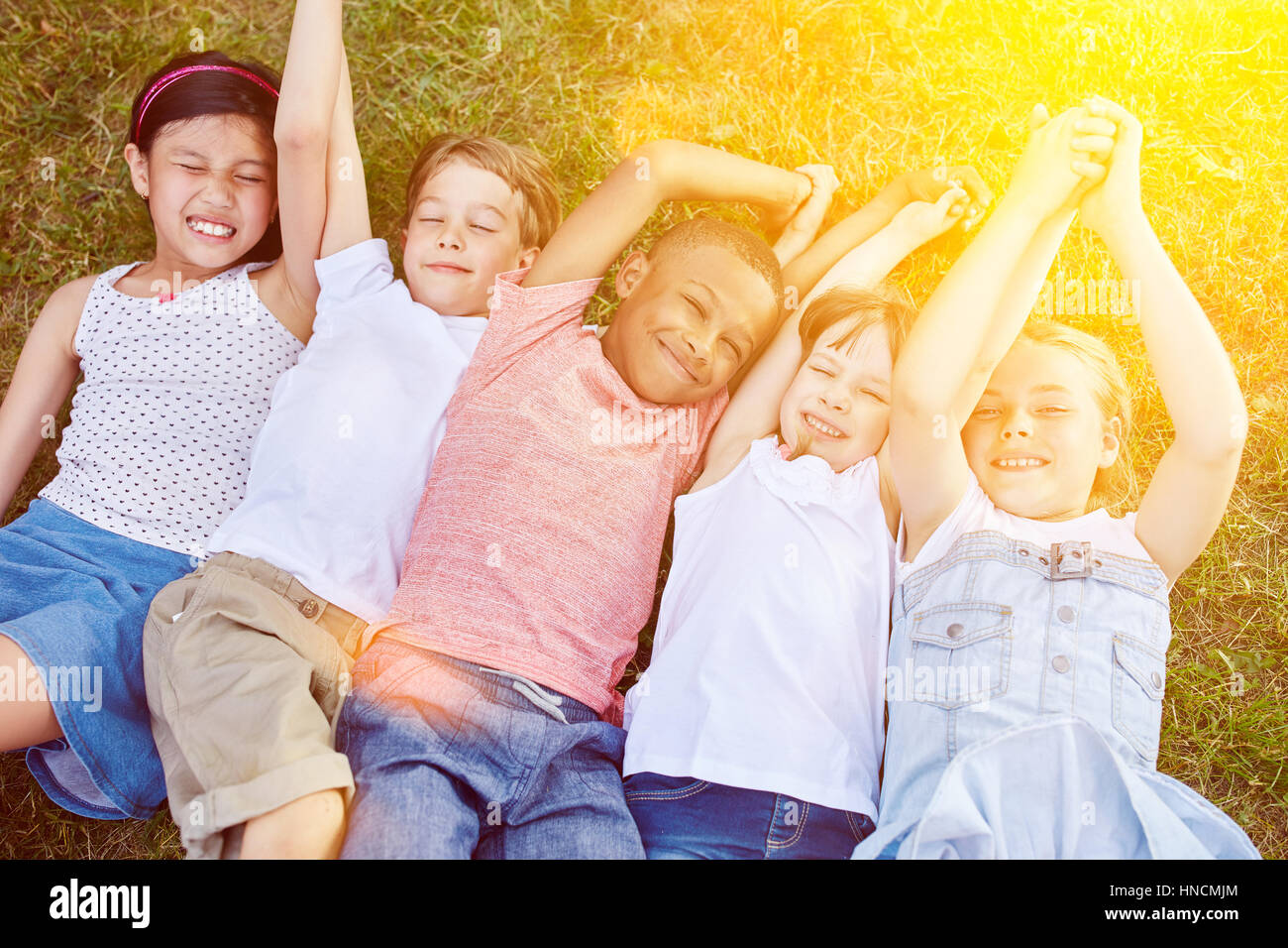 Many children on the grass in summer in the garden having fun Stock ...