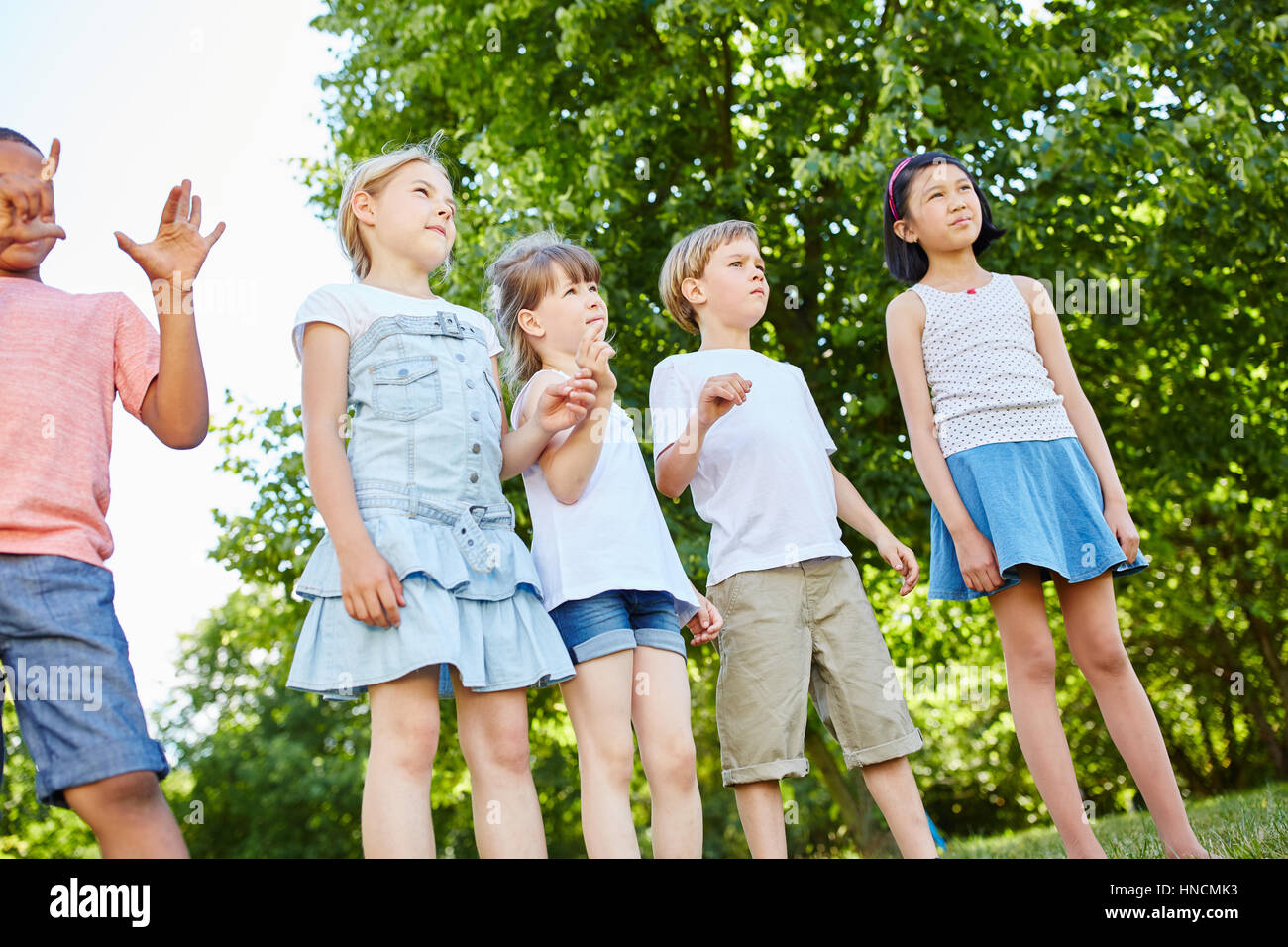Group of kids standing in the park with anticipation Stock Photo