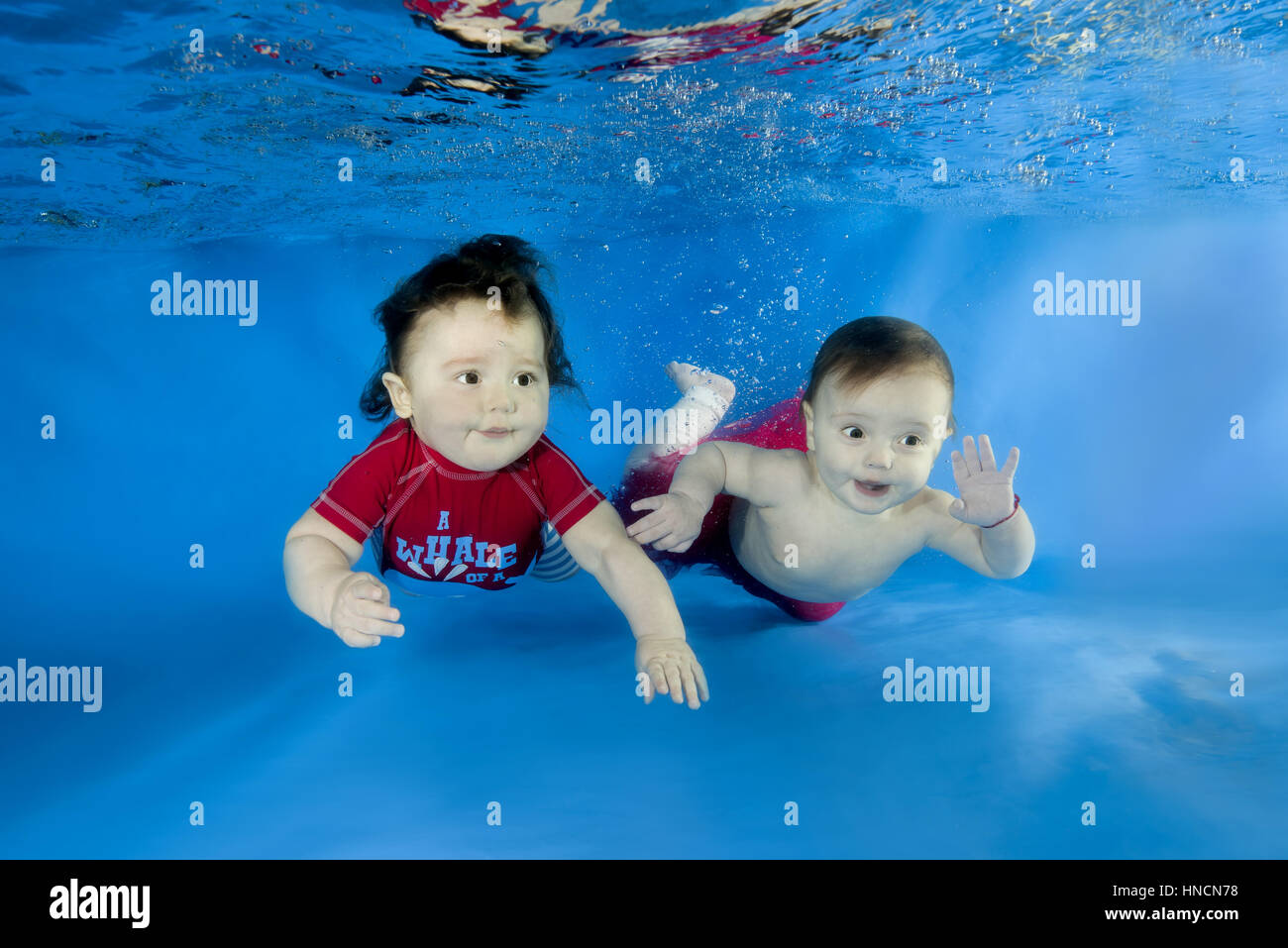 Infant, boy and girl posing under water in swimming pool, Odessa