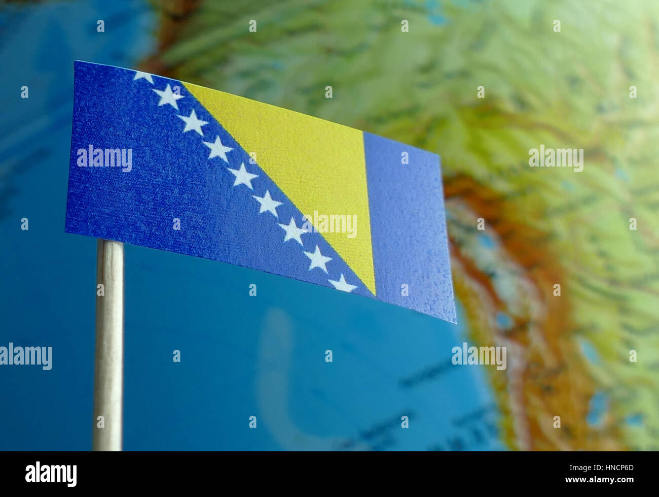 Bosnia and Herzegovina flag with a globe map as a background macro Stock Photo