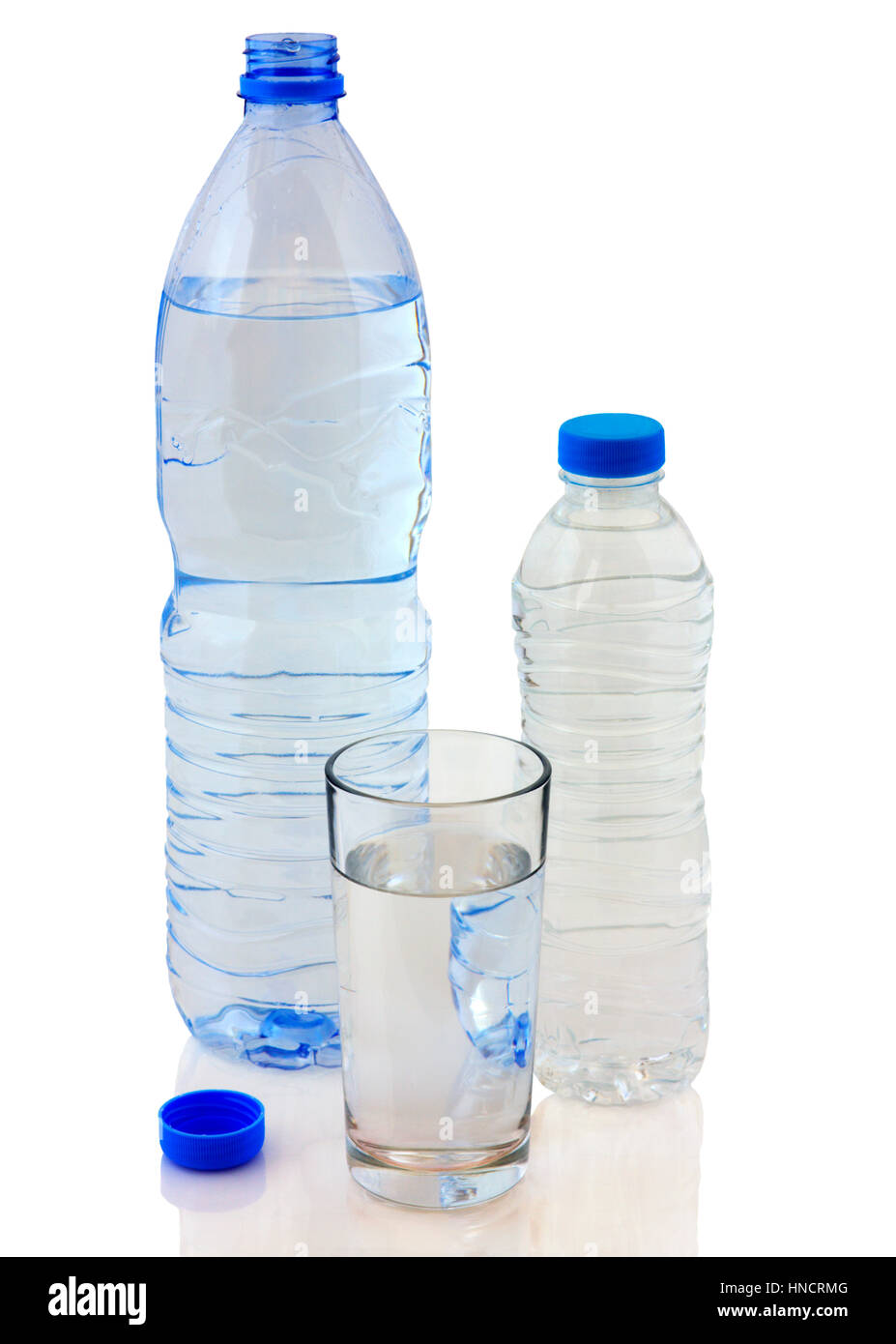 Bottles of water and glass isolated on white background closeup Stock