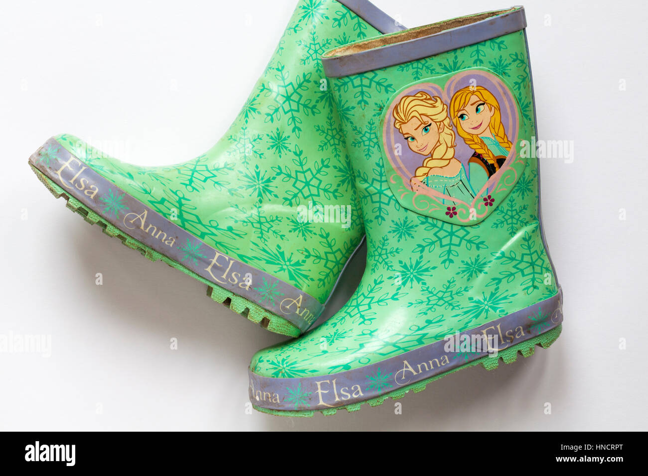 Well loved worn pair of children's wellie boots with Anna and Elsa from Frozen on set on white background Stock Photo