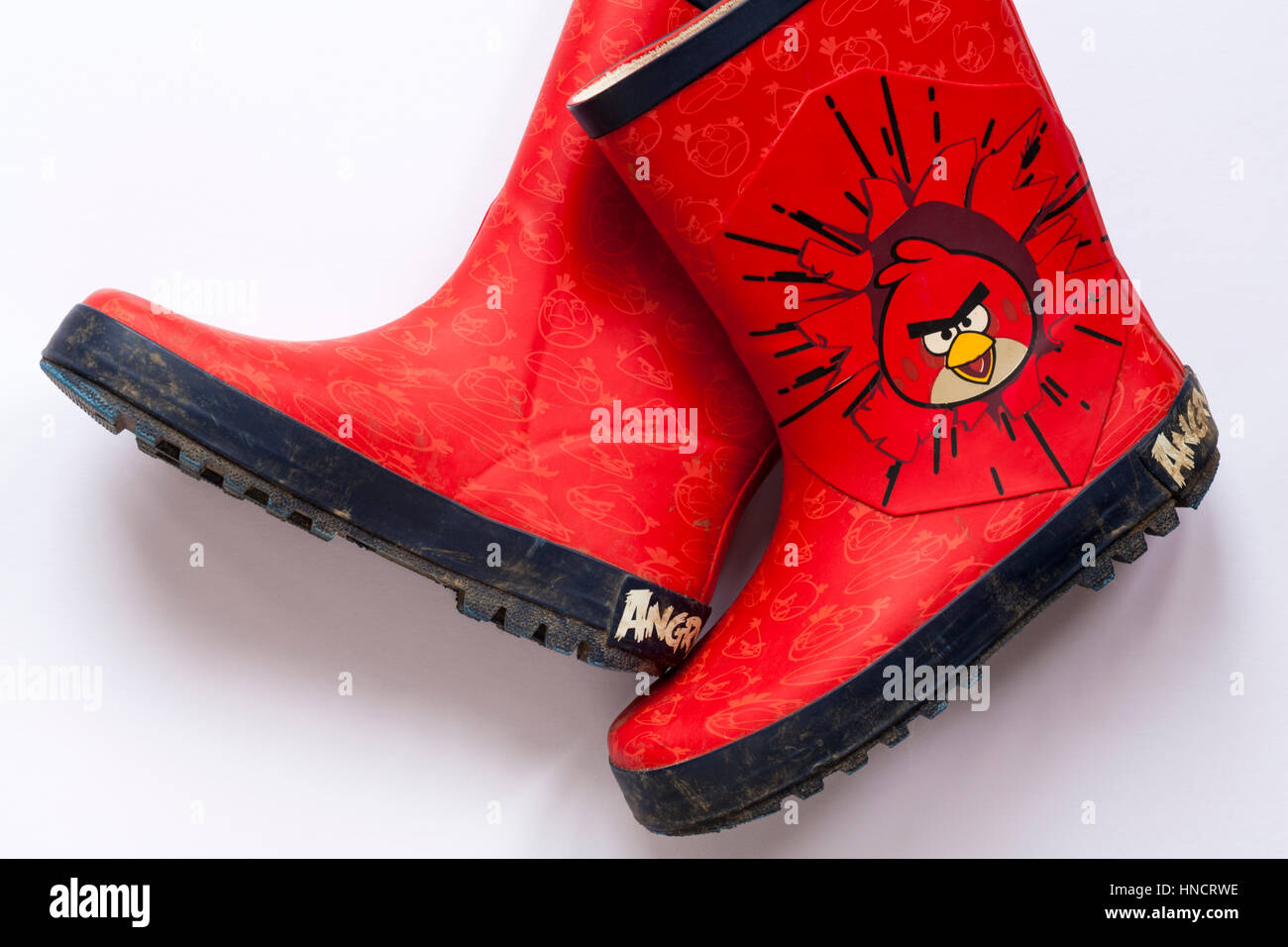Well loved used pair of children's wellie boots with Angry Birds on set on white background Stock Photo