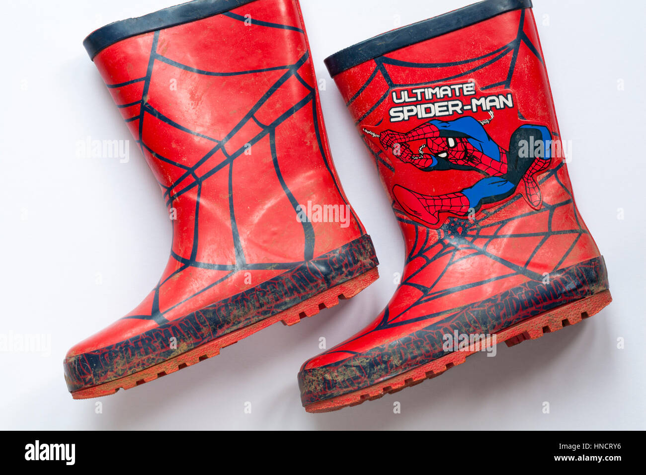 Well loved worn pair of children's wellie boots with Ultimate Spider-man on set on white background Stock Photo