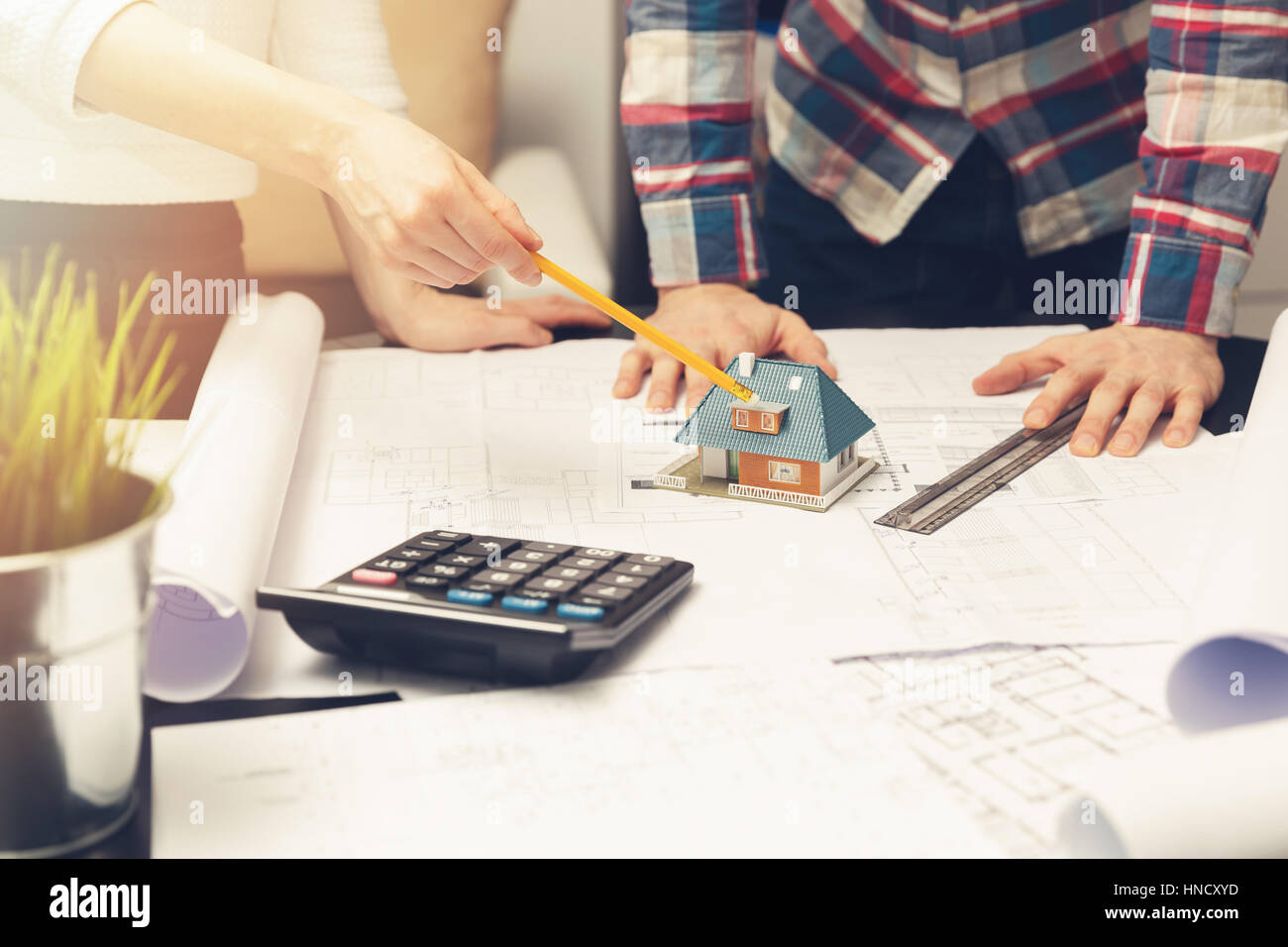 architect showing new family house model and blueprints to customer at office Stock Photo