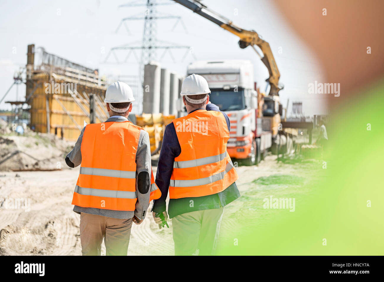 Rear view of supervisors walking at construction site Stock Photo