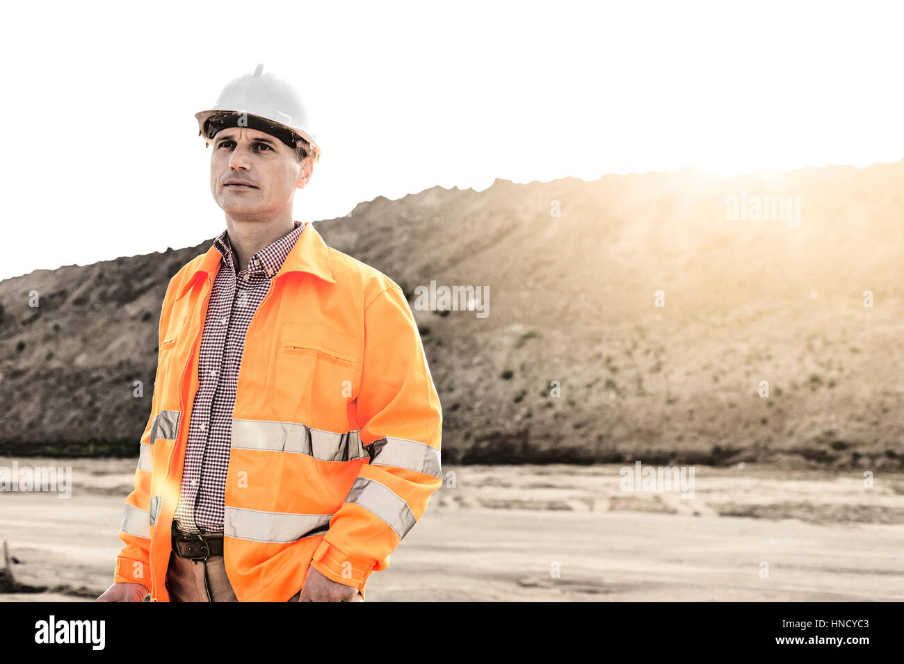 Thoughtful male supervisor looking away at construction site Stock Photo